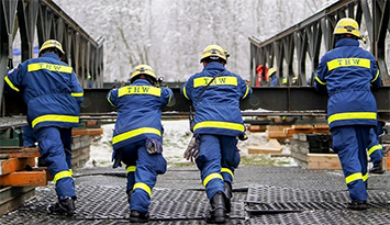Helfer des THW beim Schieben einer Brücke
